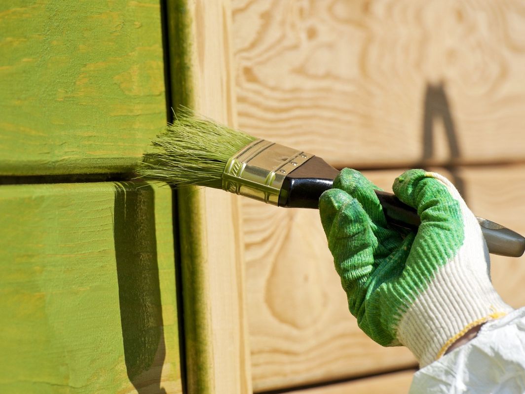 mano de pintor imprimiendo verde siobre madera