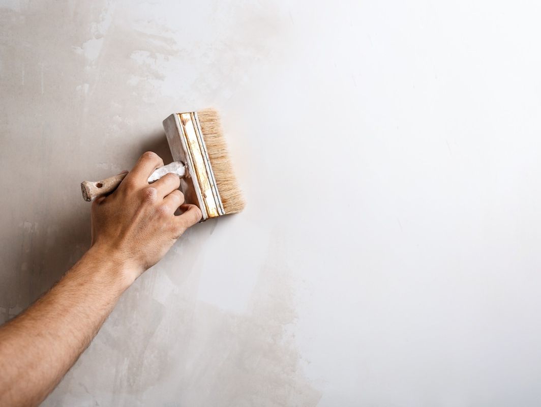 mano de pintor con brocha sobre pared